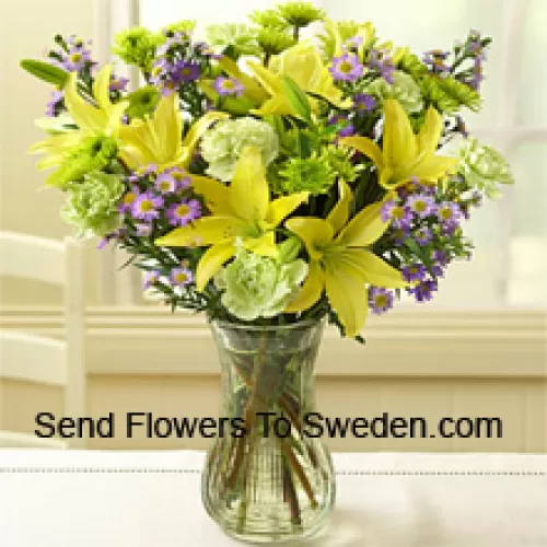 Lys jaunes et autres fleurs assorties disposés magnifiquement dans un vase en verre