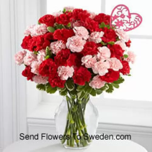 37 Carnations ( 19 Red And 18 Pink ) With Seasonal Fillers And Heart Stick In A Glass Vase